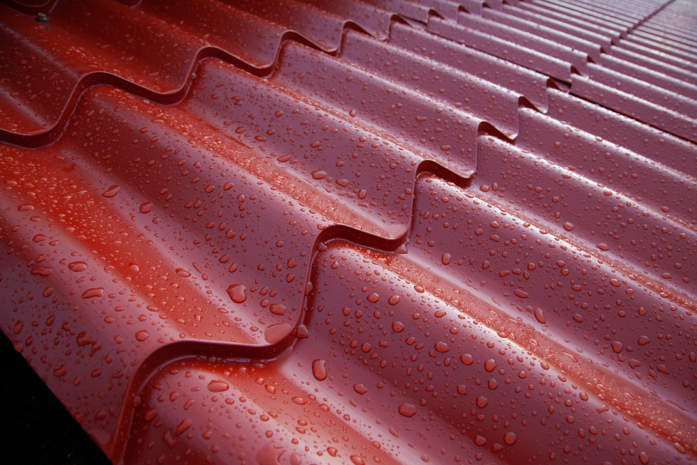 Metal red tile roof system made of corrugated painted steel sheets.
